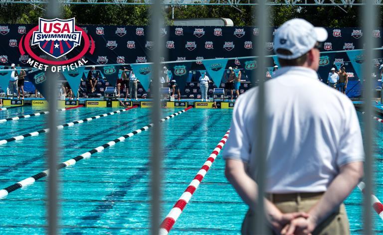 Swim meet officials watching the finish at the end of a race